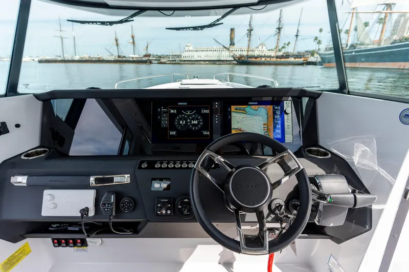 Slide: The Image of 2026 Axopar 29 XC Cross Cabin dashboard with navigation screens and steering wheel. - 48