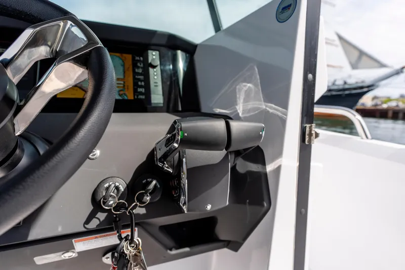 Slide: The Image of 2026 Axopar 29 XC Cross Cabin helm with steering wheel and throttle controls. - 50