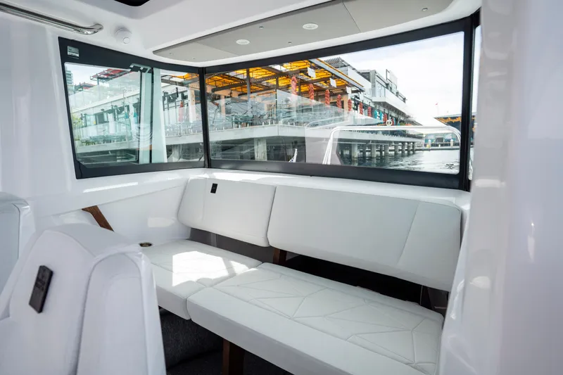 Slide: The Image of Interior of 2026 Axopar 29 XC Cross Cabin with white seating and large windows. - 53