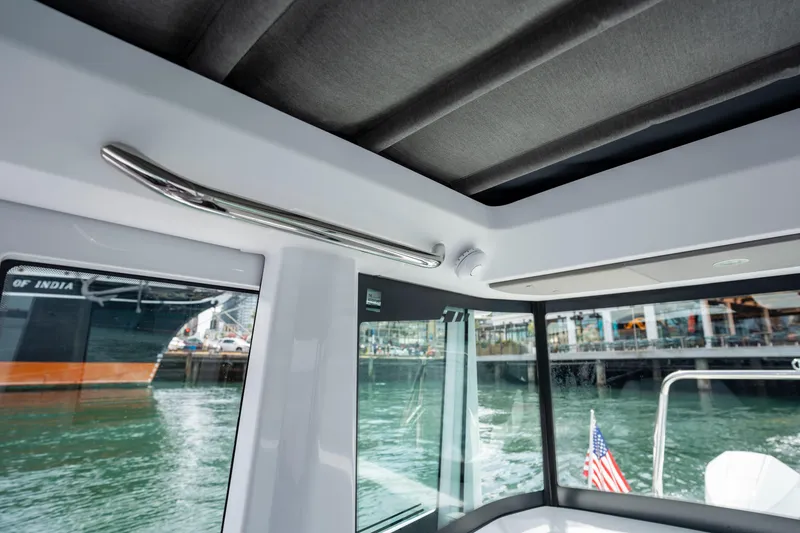 Slide: The Image of Interior view of 2026 Axopar 29 XC Cross Cabin boat with waterfront background. - 56