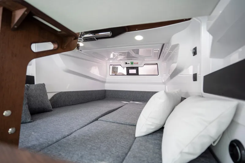Slide: The Image of 2026 Axopar 29 XC Cross Cabin interior with cozy gray seating and white pillows. - 57