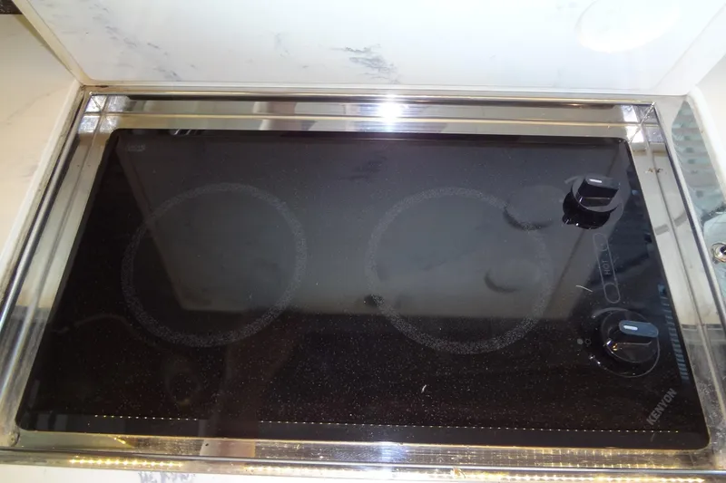 Slide: The Image of Stovetop in 2021 Cruisers Yachts 50 Cantius, featuring sleek black glass surface. - 17