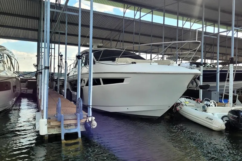 Slide: The Image of 2021 Cruisers Yachts 50 Cantius docked in a covered marina. - 2