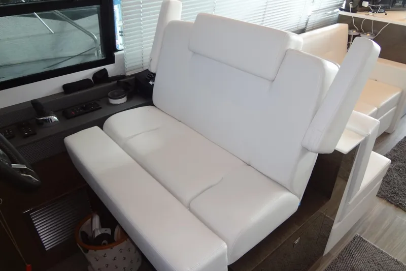 Slide: The Image of Luxurious white seating in 2021 Cruisers Yachts 50 Cantius interior helm area. - 25