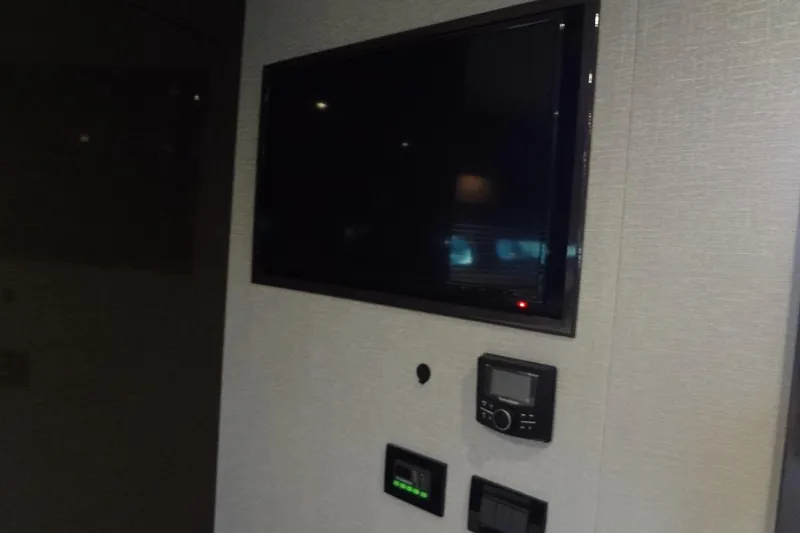 Slide: The Image of Wall-mounted TV and control panels inside 2021 Cruisers Yachts 50 Cantius. - 43