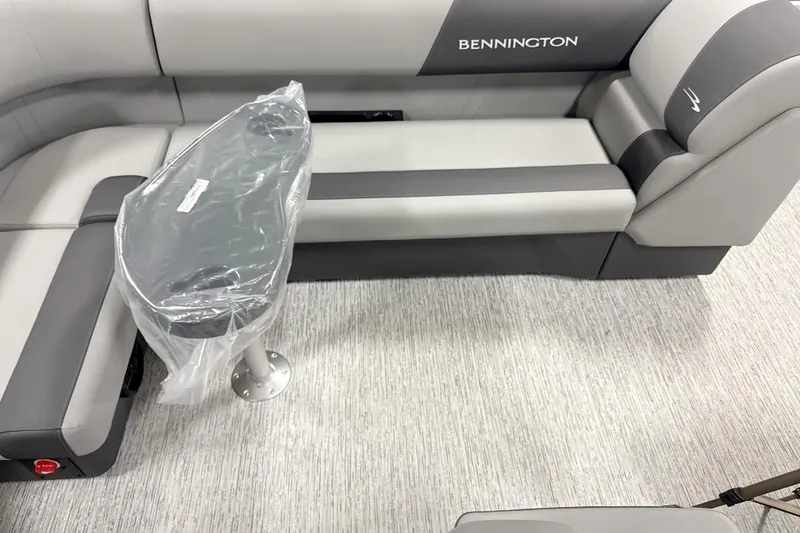 Slide: The Image of 2026 Bennington 20SL boat interior with gray seating and a covered table. - 10