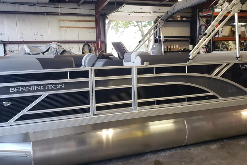Slide: The Image of 2026 Bennington 20SL pontoon boat in a garage, showcasing sleek design and modern features. - 13