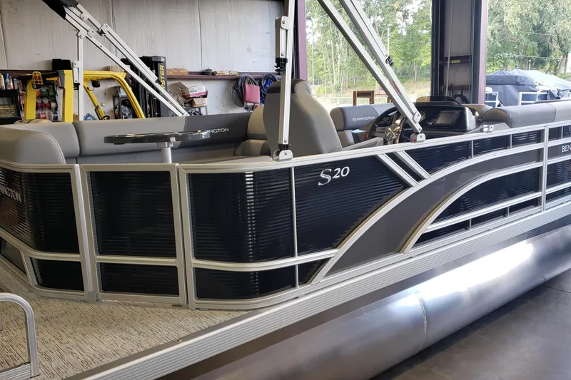 Slide: The Image of 2026 Bennington 20SL pontoon boat in a garage, featuring sleek design and modern amenities. - 14
