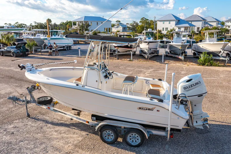 Slide: The Image of 2019 Bulls Bay 200 CC boat on trailer, parked in marina with other boats. - 2