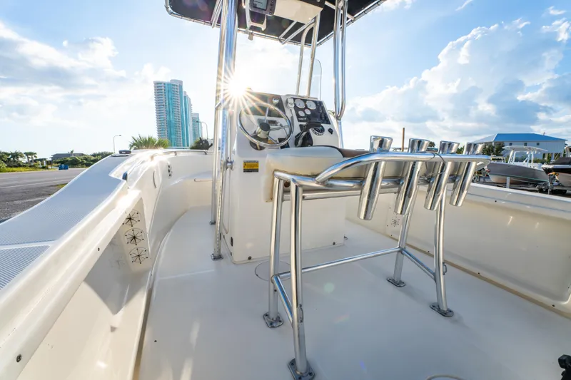 Slide: The Image of 2019 Bulls Bay 200 CC boat interior with steering console and rod holders, under sunny sky. - 24