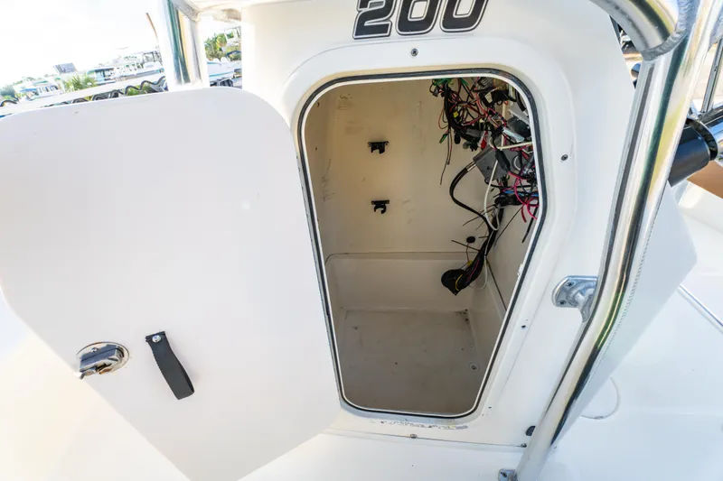 Slide: The Image of 2019 Bulls Bay 200 CC boat storage compartment with open door and visible wiring. - 25