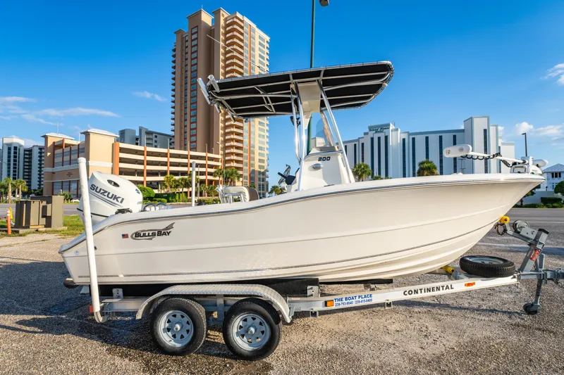 Slide: The Image of 2019 Bulls Bay 200 CC boat on trailer, urban backdrop, sunny day. - 4