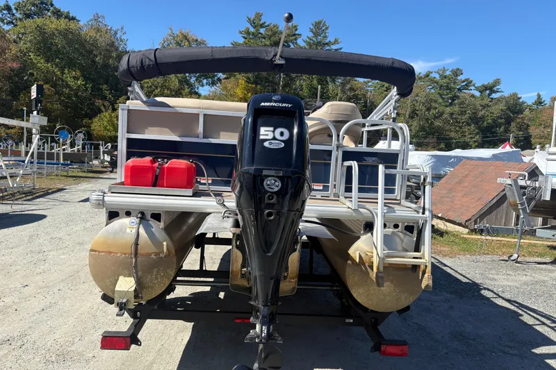 Slide: The Image of 2022 Sun Tracker Bass Buggy 16 XL pontoon boat with Mercury 50 engine, docked outdoors. - 2