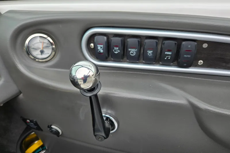 Slide: The Image of 2005 Supra Sunsport 22 V dashboard with control switches and throttle lever. - 10