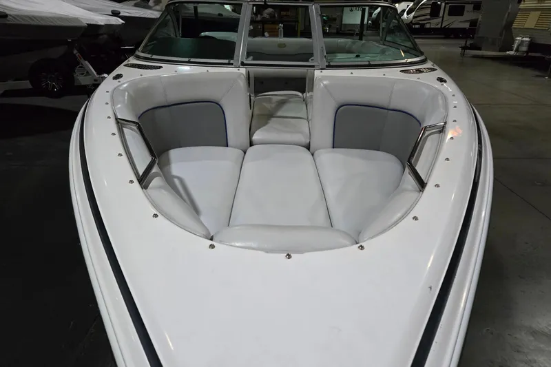 Slide: The Image of 2005 Supra Sunsport 22 V boat with white cushioned seating in a showroom. - 5