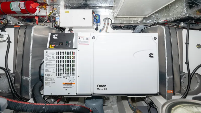 Slide: The Image of Engine room of 2023 Prestige 520S yacht with Onan generator and fire extinguisher. - 27