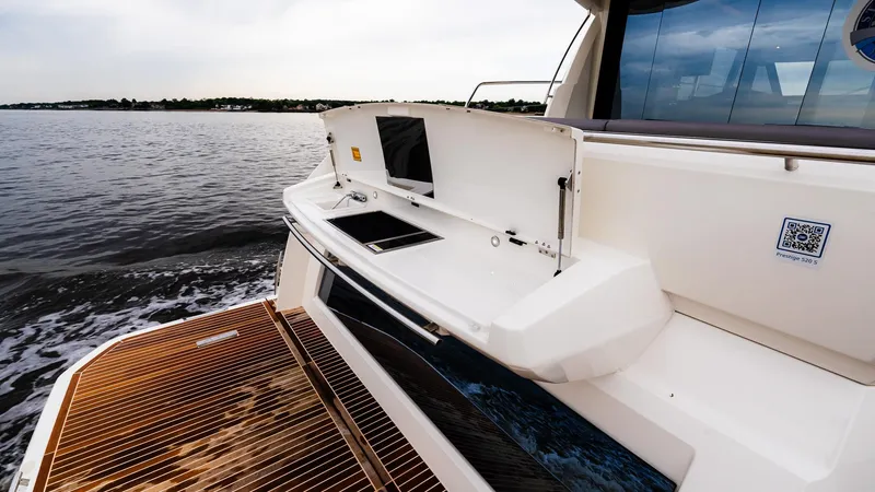 Slide: The Image of 2023 Prestige 520S yacht stern with wooden deck, cruising on calm waters. - 5