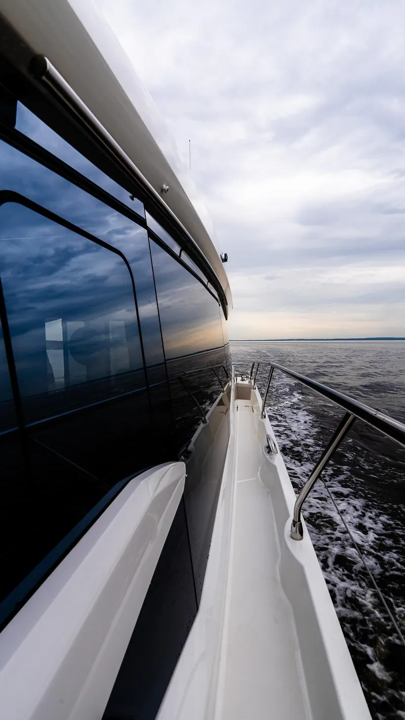 Slide: The Image of 2023 Prestige 520S yacht cruising on open water under cloudy skies. - 8