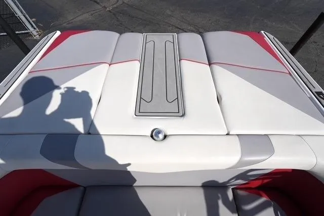 Slide: The Image of 2019 Moomba Craz boat interior with red and gray upholstery, shadow of a person taking a photo. - 16