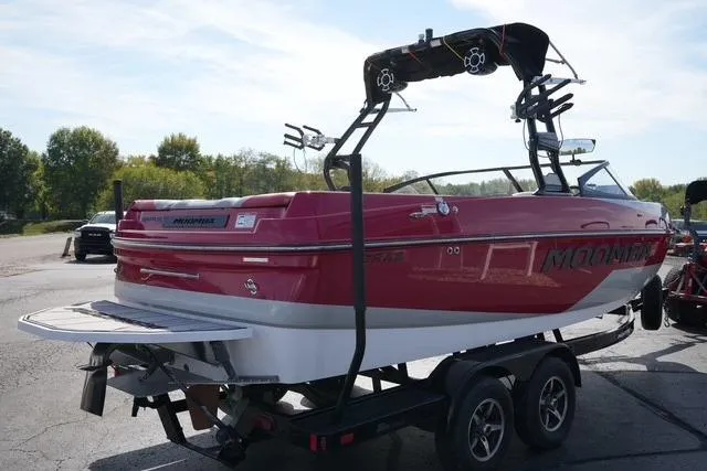 Slide: The Image of 2019 Moomba Craz boat on trailer, red and white, with wakeboard tower, parked outdoors. - 4