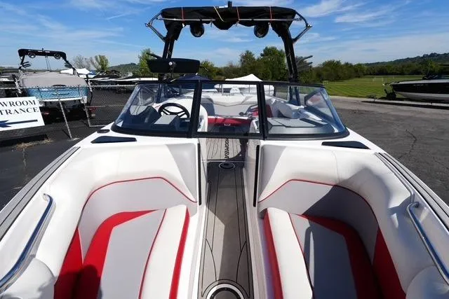 Slide: The Image of 2019 Moomba Craz boat interior with red and white seating, docked outdoors. - 9