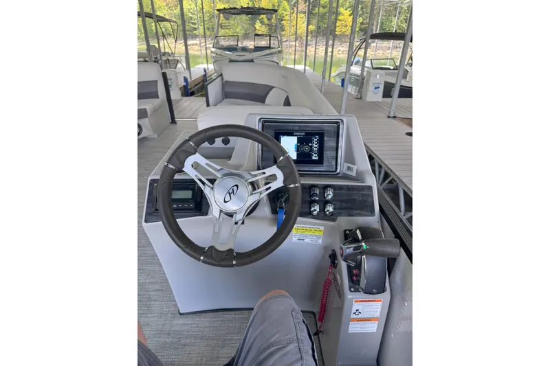 Slide: The Image of 2023 Harris Cruiser 230 boat dashboard with steering wheel and control panel. - 3