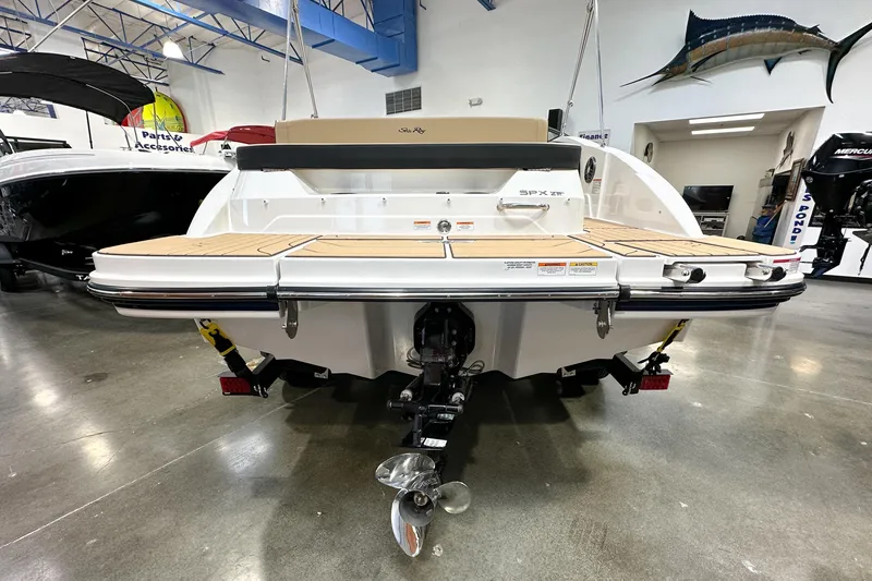 Slide: The Image of 2026 Sea Ray SPX 210 boat displayed indoors, showcasing rear deck and propeller. - 2