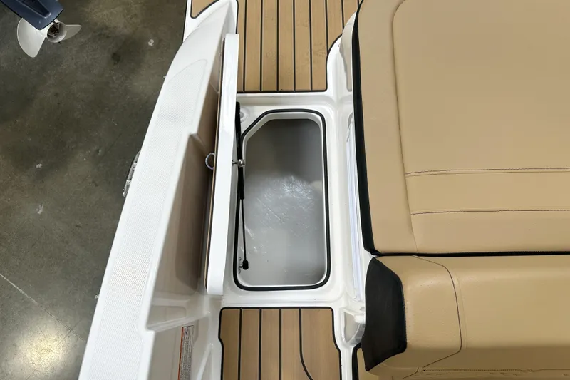 Slide: The Image of 2026 Sea Ray SPX 210 boat interior with tan seating and storage compartment. - 21