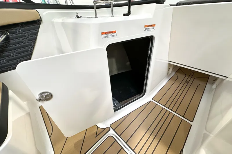 Slide: The Image of 2026 Sea Ray SPX 210 boat interior with open storage compartment and wood-patterned flooring. - 8