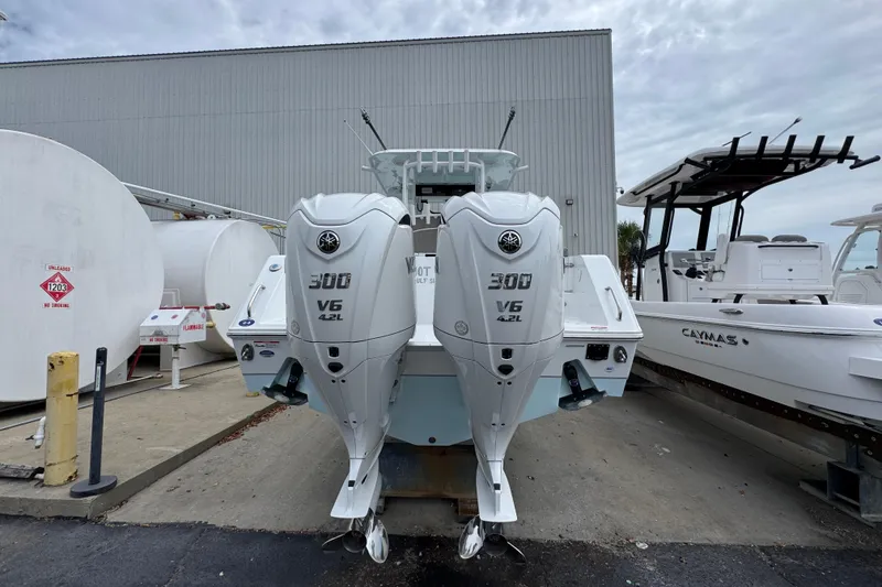Slide: The Image of 2024 Sea Hunt Gamefish 28 with twin 300 V6 engines, docked near fuel tanks. - 11