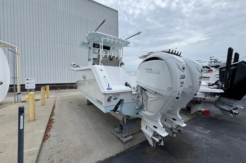 Slide: The Image of 2024 Sea Hunt Gamefish 28 boat with dual Yamaha engines, docked outdoors. - 13