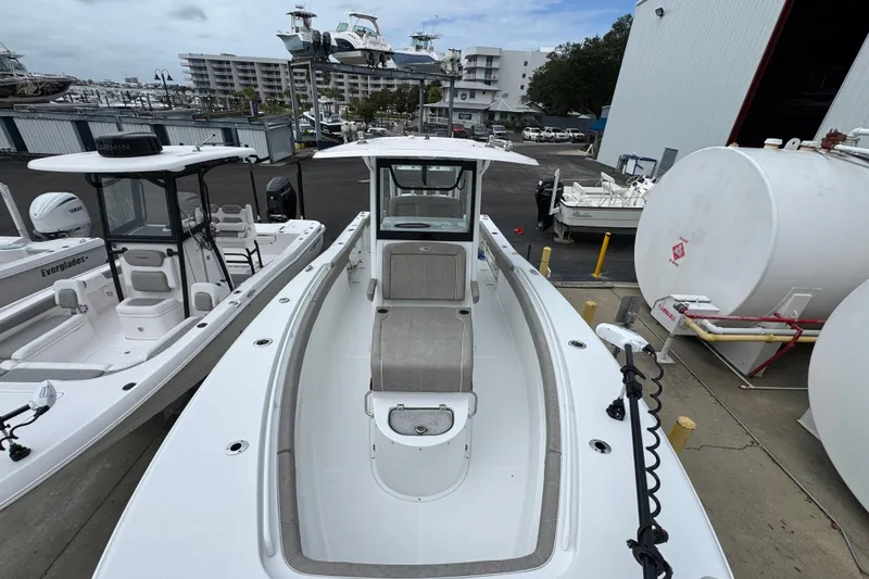 Slide: The Image of 2024 Sea Hunt Gamefish 28 boat at marina, surrounded by other vessels and storage tanks. - 20