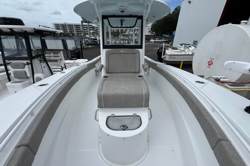 Slide: The Image of 2024 Sea Hunt Gamefish 28 boat interior with seating and storage, docked at marina. - 21