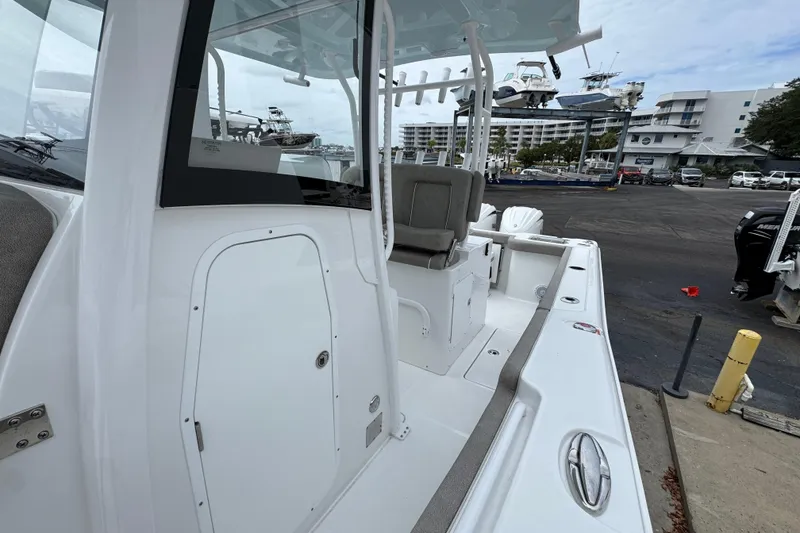 Slide: The Image of 2024 Sea Hunt Gamefish 28 boat interior at marina, showcasing seating and storage. - 22