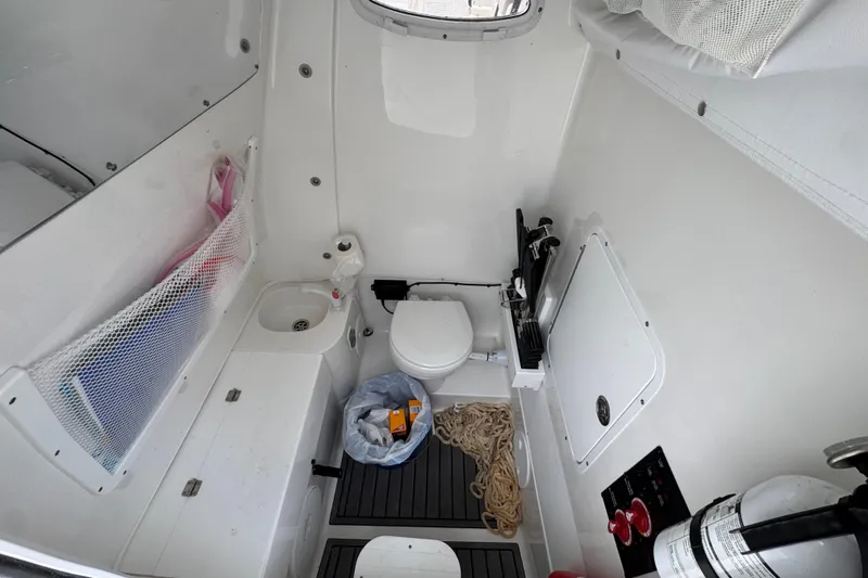 Slide: The Image of 2024 Sea Hunt Gamefish 28 boat interior with toilet, sink, and storage. - 24