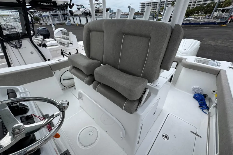 Slide: The Image of 2024 Sea Hunt Gamefish 28 boat interior with gray cushioned seating and steering wheel. - 25