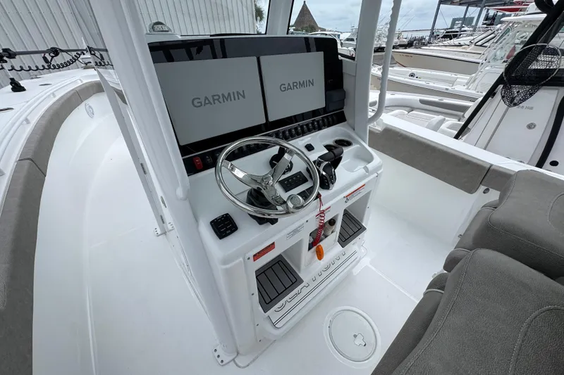 Slide: The Image of 2024 Sea Hunt Gamefish 28 boat console with Garmin displays and steering wheel. - 28