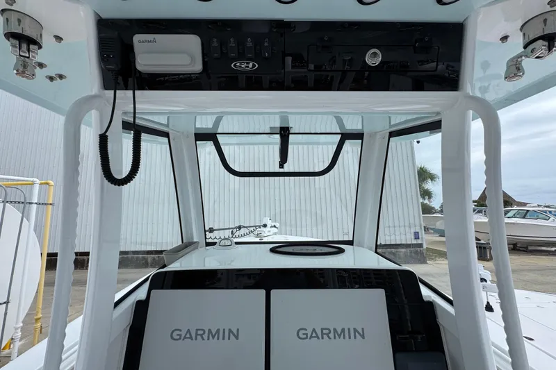 Slide: The Image of 2024 Sea Hunt Gamefish 28 boat console with Garmin electronics and overhead storage. - 30