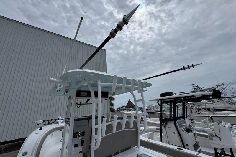 Slide: The Image of 2024 Sea Hunt Gamefish 28 boat with fishing equipment, docked under cloudy sky. - 35