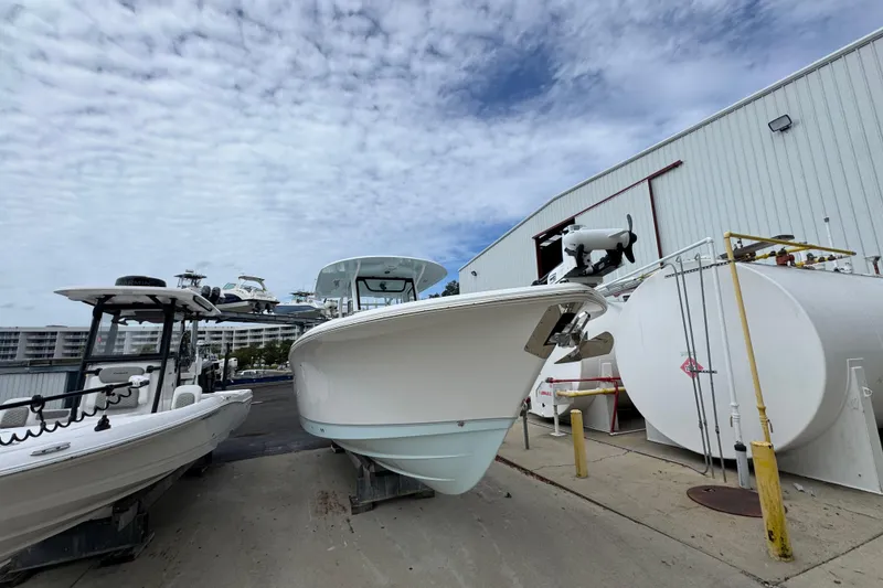 Slide: The Image of 2024 Sea Hunt Gamefish 28 boat docked near a marina under a cloudy sky. - 6