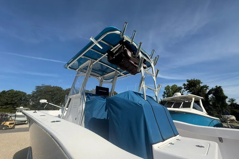 Slide: The Image of Valentino 28CC boat, 2020 model, with blue canopy and rod holders, under clear sky. - 13