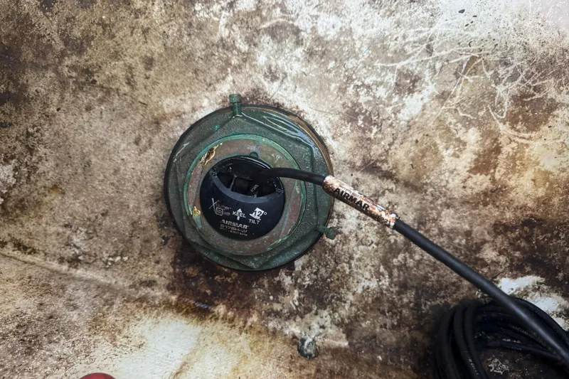 Slide: The Image of Valentino 28CC 2020 boat component with Airmar sensor and cable on weathered surface. - 18