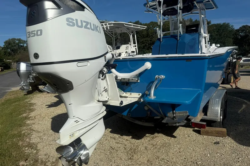 Slide: The Image of 2020 Valentino 28CC boat with Suzuki 350 outboard motor, parked on gravel. - 2