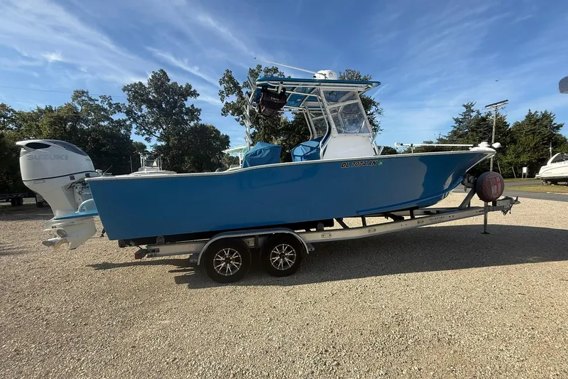 Slide: The Image of Blue 2020 Valentino 28CC boat on trailer, parked outdoors under clear sky. - 7