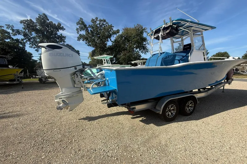 Slide: The Image of Blue Valentino 28CC boat with Suzuki outboard motor on a trailer, parked outdoors. - 8