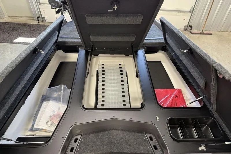 Slide: The Image of 2025 Skeeter ZXR20 boat storage compartments with open lids, showcasing organized interior space. - 12