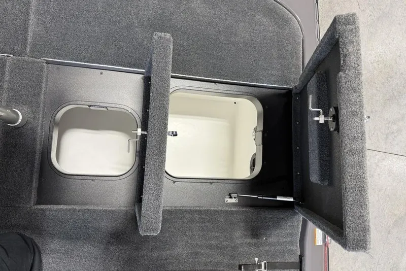 Slide: The Image of Interior storage compartments of 2025 Skeeter ZXR20 boat, featuring carpeted lids and secure latches. - 20