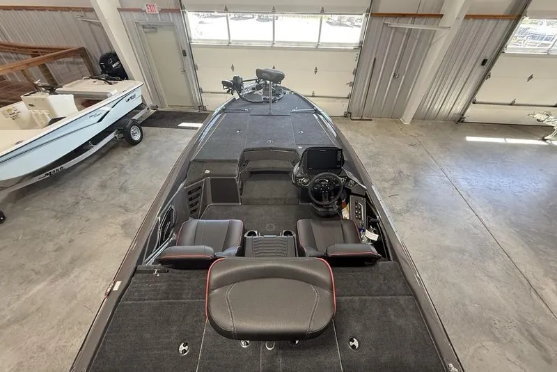 Slide: The Image of 2025 Skeeter ZXR20 boat interior with modern dashboard and seating in a garage. - 21