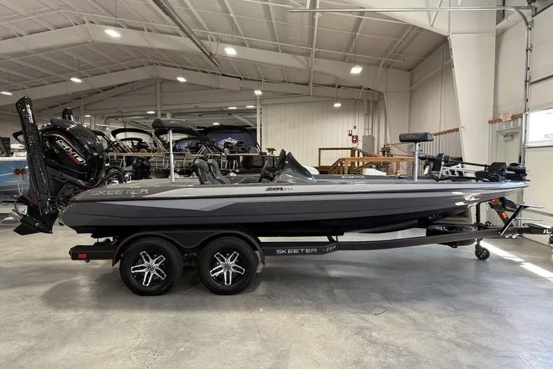 Slide: The Image of 2025 Skeeter ZXR20 boat in showroom, featuring sleek design and dual-axle trailer. - 4