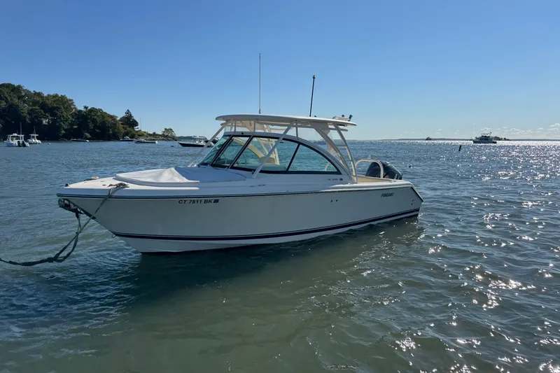 Slide: The Image of 2012 Pursuit DC 265 Dual Console boat anchored on sunny water. - 11